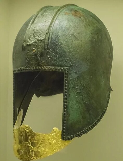  Funerary bronze helmet with gold mouth piece from the necropolis at Archontiko Greek 560-550 BCE. The gold mouthpiece is decorated with an embossed star. Embossed dots of various sizes in simple geometric forms cover the remaining surface. 